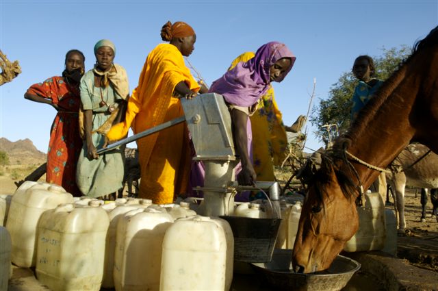 Women pumping water from a well